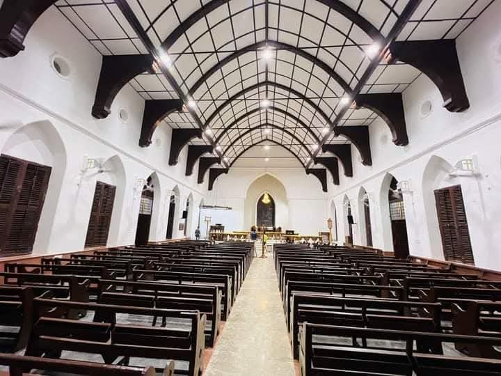 The sanctuary of Wesley Church — timber-arched ceiling over rows of wooden pews